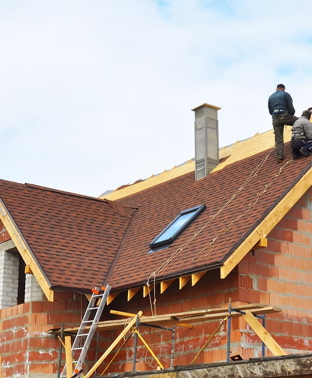 Roofing crew working on a shingle roof